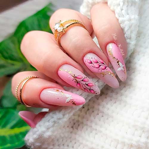 Long almond baby pink nails with two accent blossom nails besides gold glitter and white butterflies for spring 2022