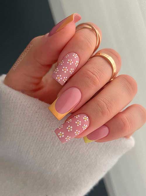 Long square shaped yellow spring French nails with two accent white flower nails that have matte nude base color