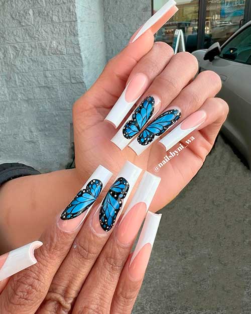 Long square shaped white French tip nails with big blue butterfly nail on two accents