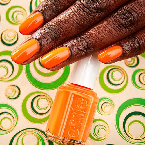 Vibrant short orange nails use Movin’ & Groovin’ Essie nail polish