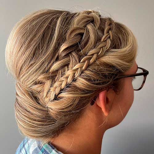 Soft chignon updo with a loose boho braid and another mini braid for prom