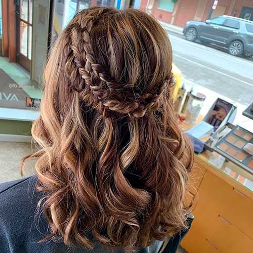 Medium length half up triple braided boho hairstyle with loose wavy hair for prom