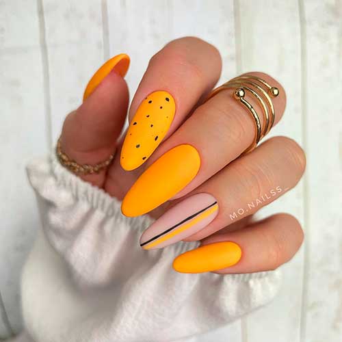 Long Almond Matte Orange Obsession Summer Nails with Black dots and Lines on Ring Fingernail