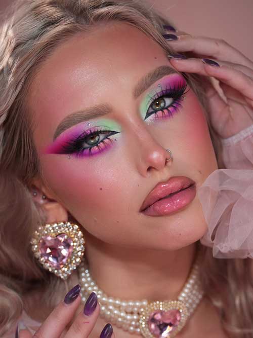 Artistic summer makeup with a gradient of pink, green, and purple eyeshadows, smoky eyeliner, long lashes, and rhinestone accents. Artistic summer makeup with a gradient of pink, green, and purple eyeshadows, smoky eyeliner, long lashes, and rhinestone accents.