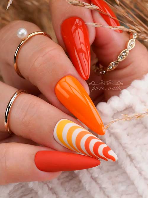 Glossy almond burnt orange nails with striped nail art design, and accent matte burnt orange nail