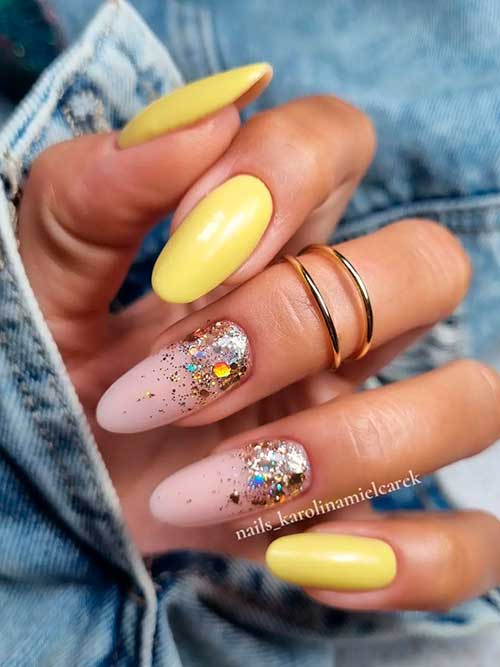 Cute yellow nails with sparkling glitter on two nude pink accent nails for summertime