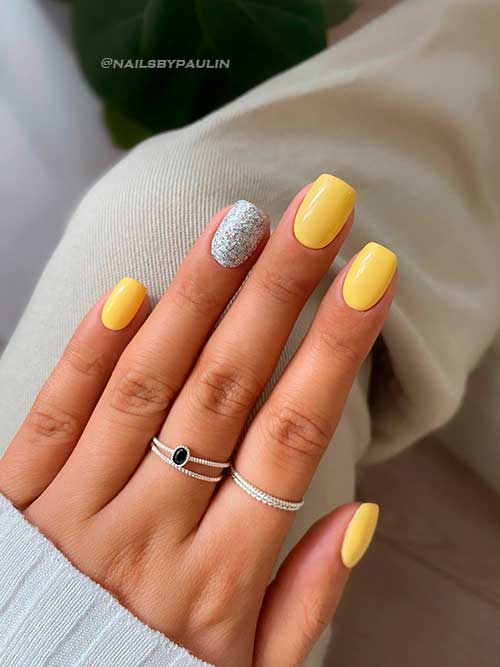 Short yellow nail design with silver accent