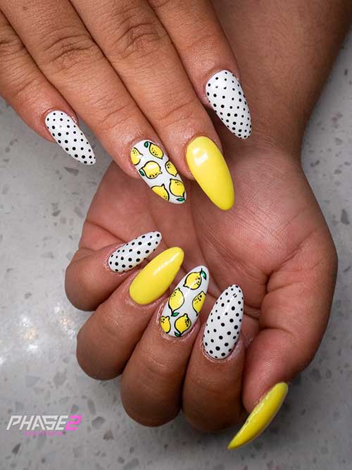 Medium almond shaped white polka dot nails with citrus nail art and accent yellow nail