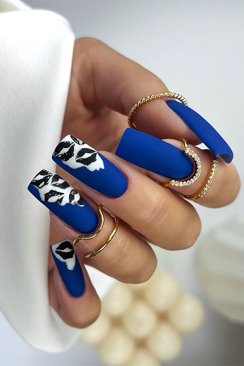 Long square-shaped matte navy blue nails with black lip nail art kisses over a white base color on three accent nails Long square-shaped matte navy blue nails with black lip nail art kisses over a white base color on three accent nails