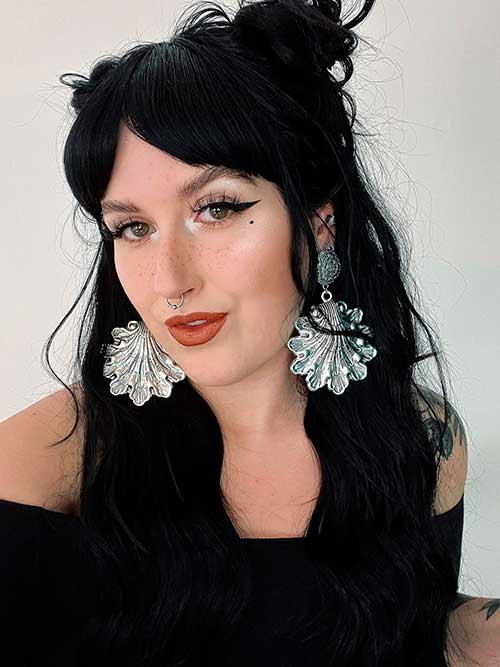 Fall makeup look with winged eyeliner, brown lips, and mermaid earrings
