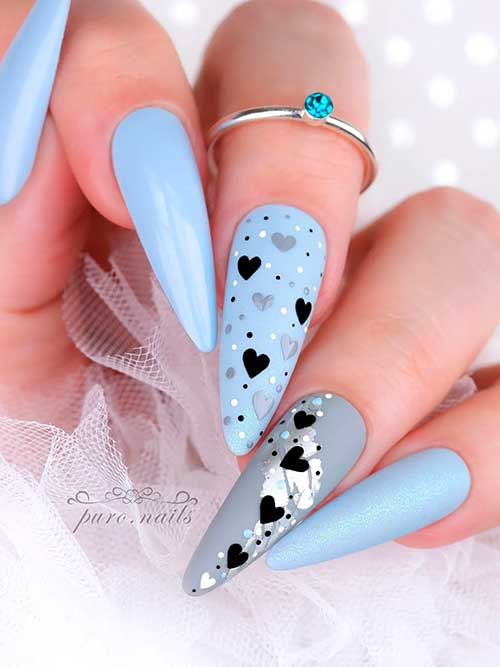 Long almond-shaped ice blue valentine’s nails 2023 with black and gray hearts and a gray accent nail