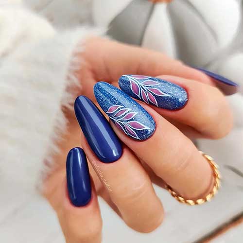 Long Round Shaped Navy Blue Nails with Leaf Nail Art on Two Glitter Accent Nails