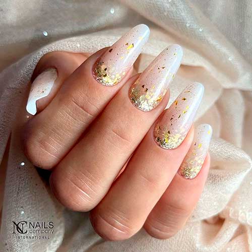 Long round winter nude acrylic nails with gold glitter