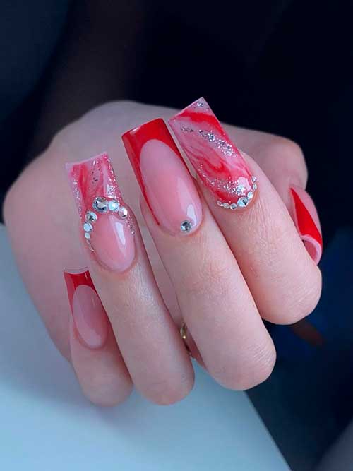 Long Square Red French Tip Nails with Two Red Marble Accent Nails Adorned with Silver Rhinestones and Glitter