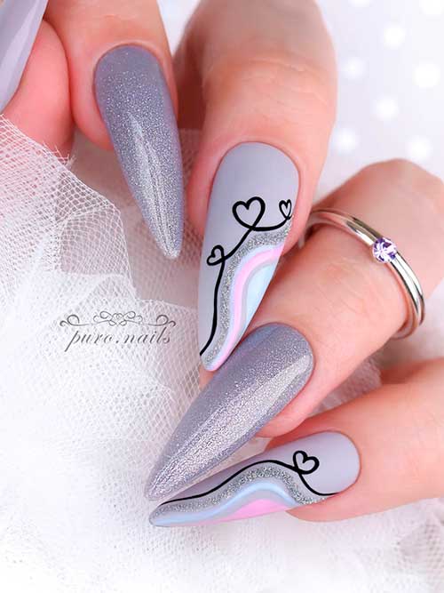Long almond glossy, glitter, and matte grey nails with black heart shapes for Valentine’s Day