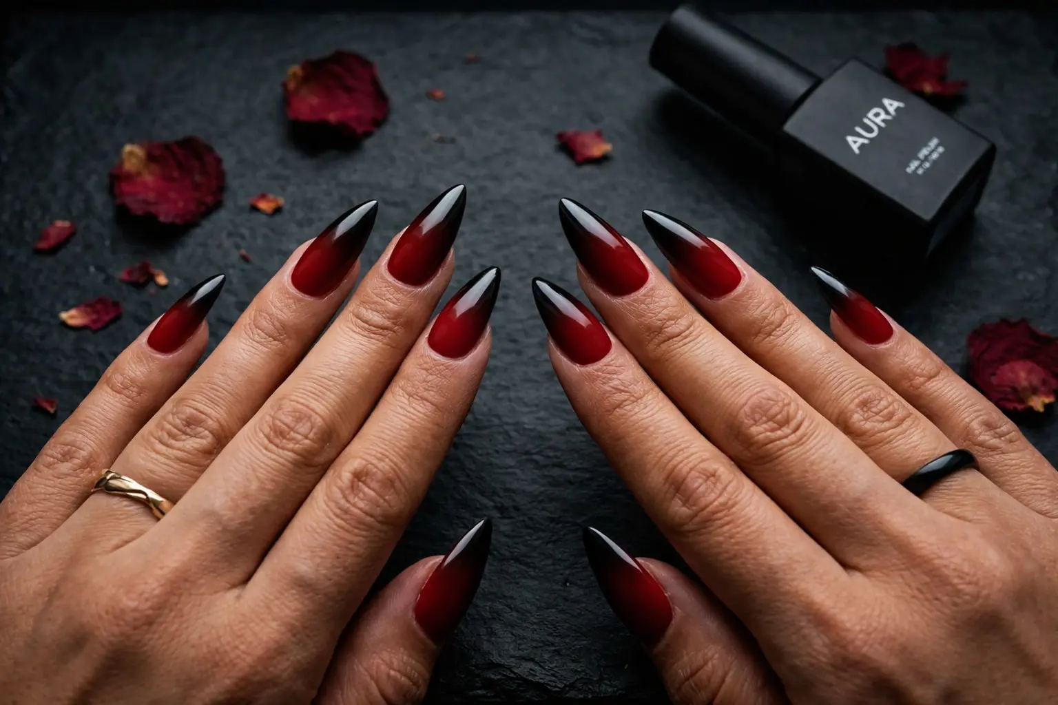 Long stiletto nails with a deep red to black ombre gradient on warm-toned hands, photographed in moody editorial lighting against a dark matte surface Long stiletto nails with a deep red to black ombre gradient on warm-toned hands, photographed in moody editorial lighting against a dark matte surface