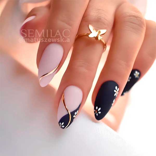 Medium almond-shaped matte nude and black spring nails with gold swirls and daisy flowers