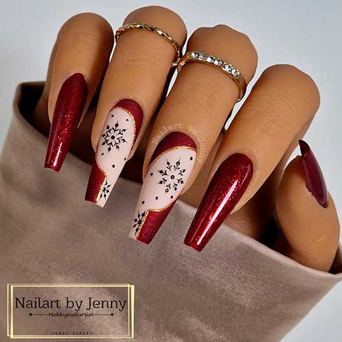Festive Dark Red Nails with Black Snowflakes on Nude Pink Accent Nails Adorned with Gold Glitter Outlines