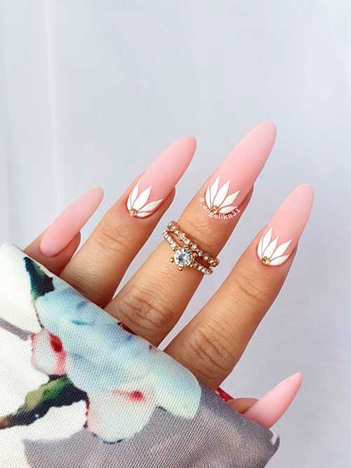 Unique Nude Nails Long round shaped matte nude pink nails with white flowers and a rhinestone on three accent nails