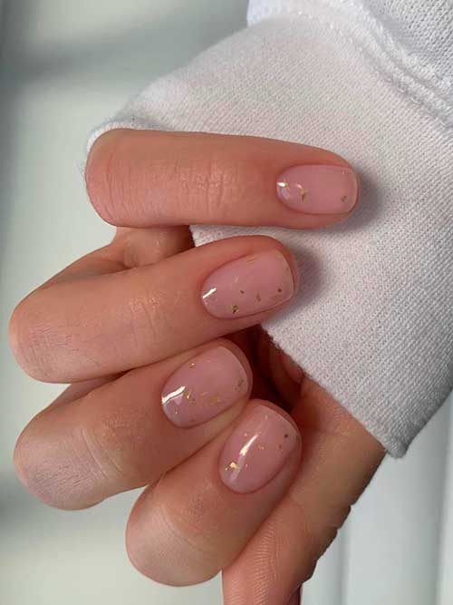 Short sheer nude nails with gold flecks that will make your outfit stand out