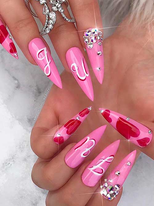 Long Stiletto pink valentine’s day nails with rhinestones and red hearts