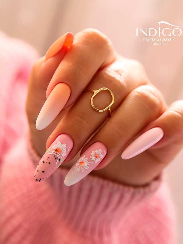 Long almond pink spring nails with ombre style and white flowers on black speckles on two nail accents