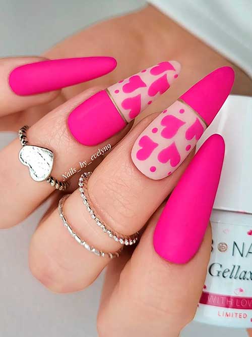 Long almond-shaped matte hot pink valentine nails 2023 with hearts on a nude pink base color