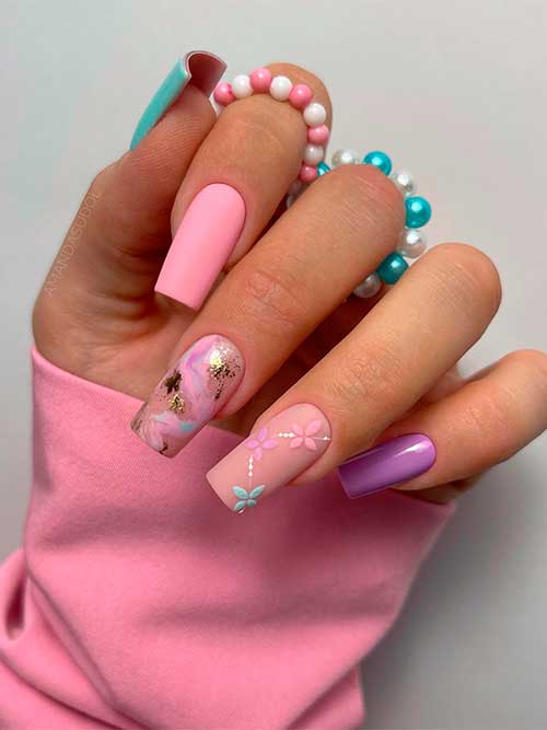 Long square-shaped matte spring pastel nails that feature mint green, purple, and pink flowers with gold foil on accents