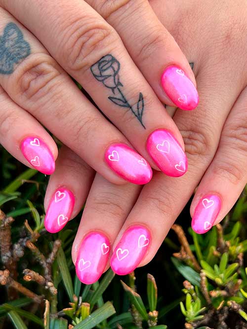 Short Pink Valentine’s Nails Short pink valentine’s nails with white heart shapes