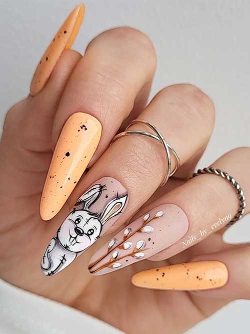 Long Almond Shaped Deep Champagne Easter Nail Design with Black Speckles, Bunny, and Leaf Nail Art
