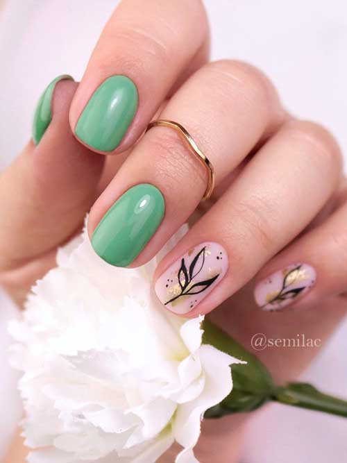 Short Green and Nude Pink Nail Design Short Green and Nude Pink Nails with Black Leaf Nail Art and Gold Glitter on Two Accent Nails