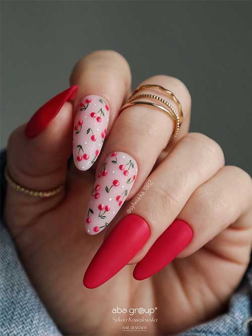 Long almond matte cherry red nails with cherry fruits on two nude pink accent nails
