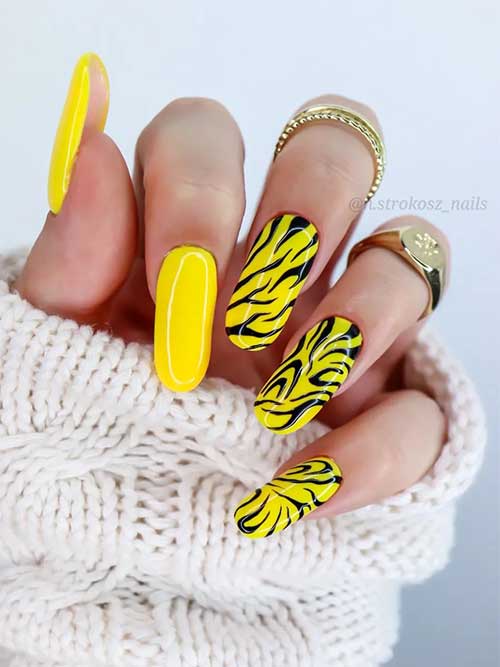 Long round bright yellow nails with zebra prints for summer 2023