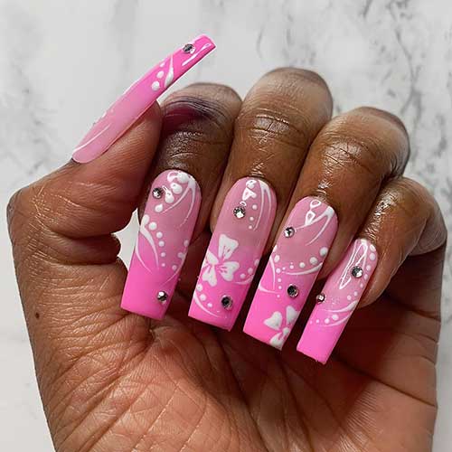 Long square shaped pink ombre French Tip y2k nails with rhinestones and white floral nail art