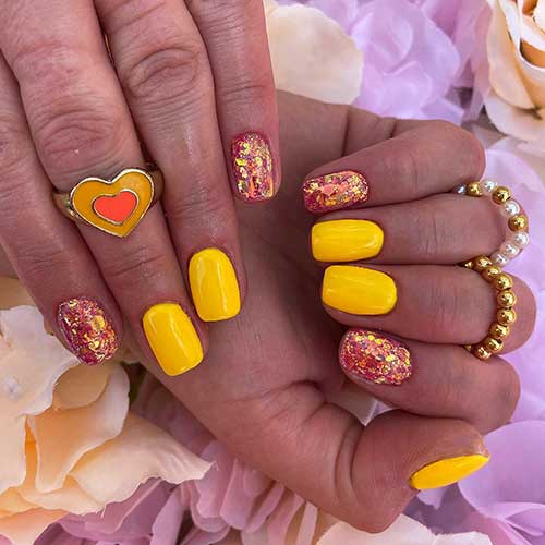 Short square bright yellow nails with glitter on two accent nails Short square bright yellow nails with glitter on two accent nails