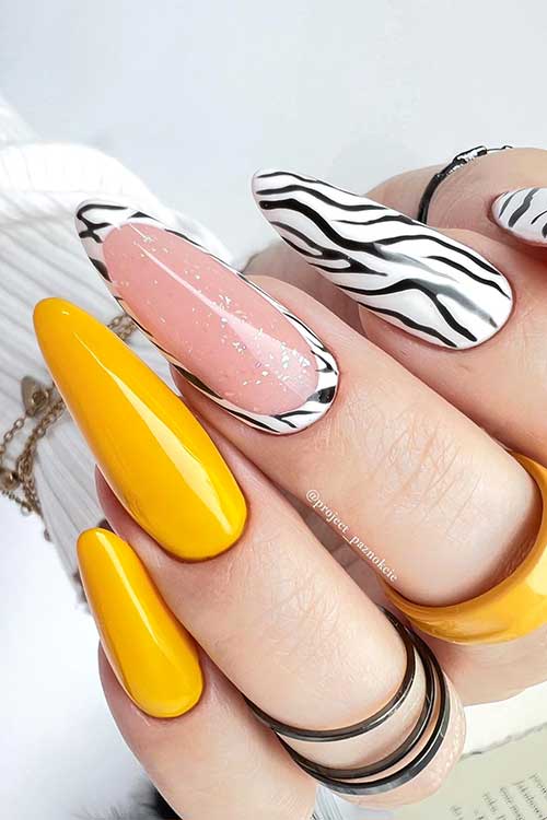 Long almond shaped yellow with black zebra print nails on white base color