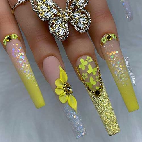 Long coffin ombre neon yellow acrylic nails with glitter, rhinestones, and flowers