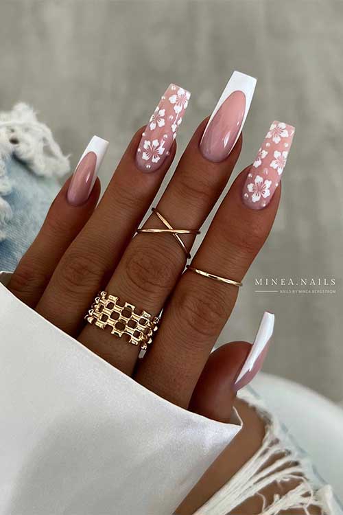 Long coffin white French nails with white flowers on two nude accent nails