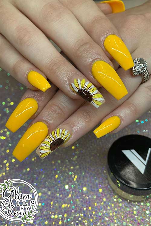 Long coffin yellow acrylic nails with sunflower on an accent nail