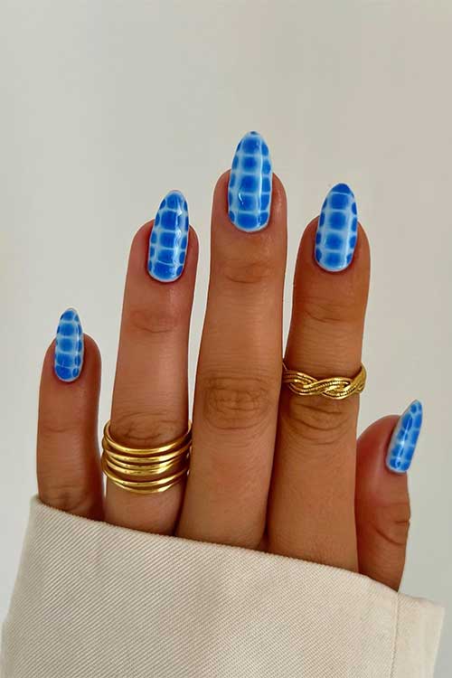 Medium almond shaped blue snake print nails over light blue base color