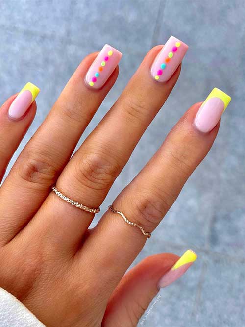 Medium square neon yellow French tips with center colorful dots on two accent nude nails Medium square neon yellow French tips with center colorful dots on two accent nude nails