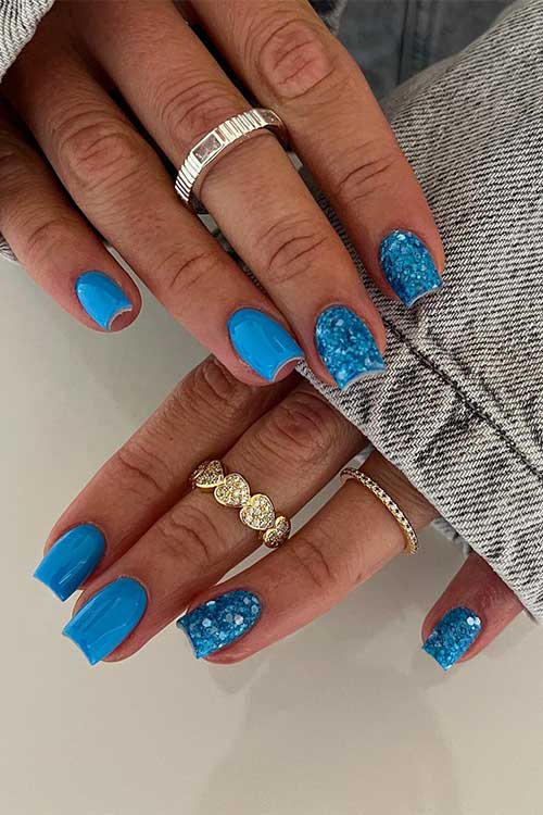 Short blue summer nails with glitter on two accent nails