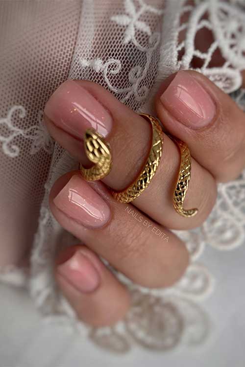 Short nude nails with a little gold glitter for summer 2023