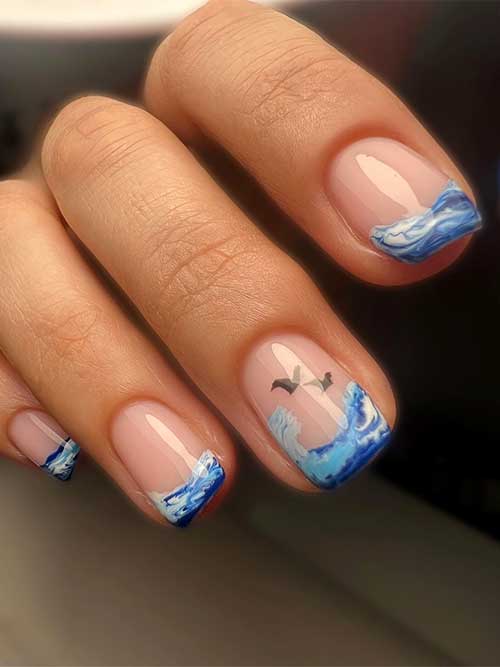 Short ocean French tip nails with black birds on an accent nail