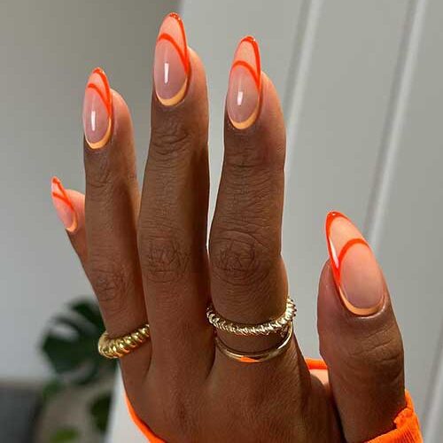 Long almond shaped neon orange and peach negative space French tip august nails