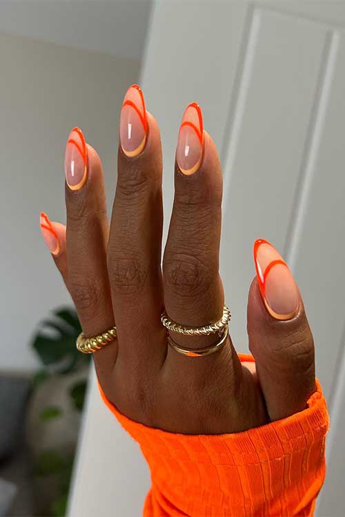 Long almond shaped orange and peach negative space French tip august nails Long almond shaped orange and peach negative space French tip august nails