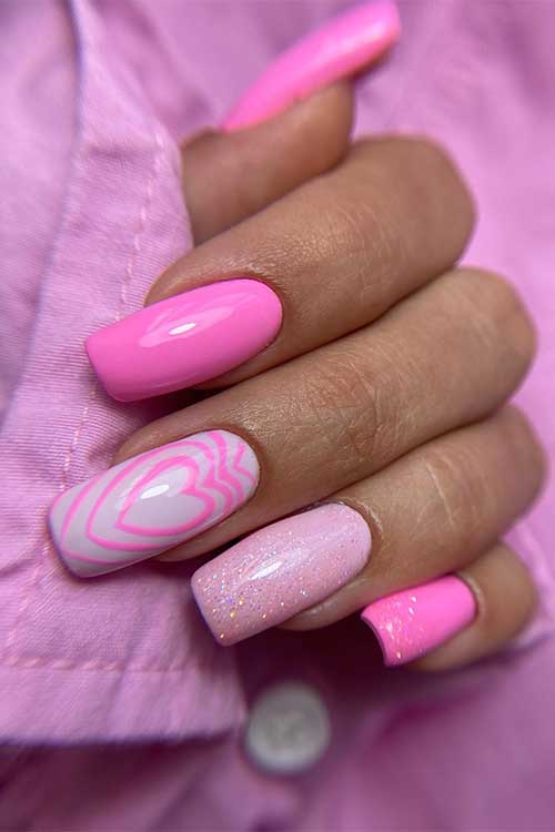 Long square shaped Barbie pink nails with glitter and heart shapes on a white accent nail Long square shaped Barbie pink nails with glitter and heart shapes on a white accent nail