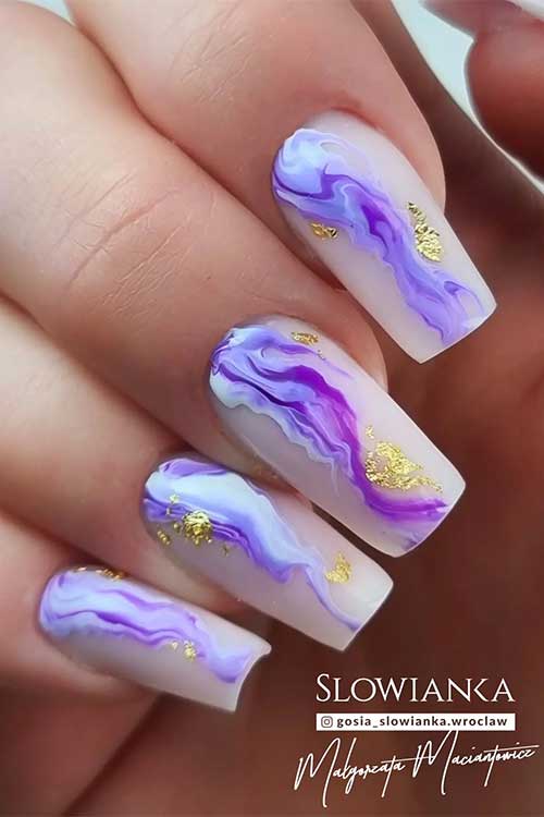Long square shaped milky white nails with purple marble nail art and gold glitter patches 