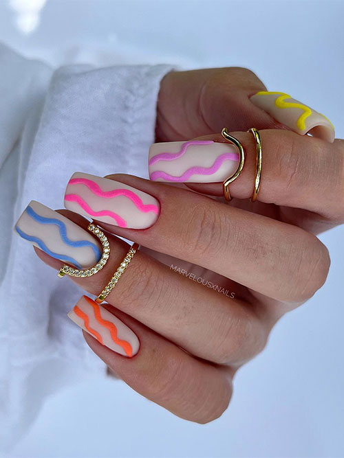 Long square shaped with matte yellow, purple, pink, blue, and orange swirls on matte white nude base color