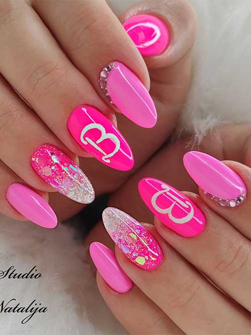 Short almond shaped different pink Barbie Logo Nails with glitter and rhinestones on accent nails Short almond shaped different pink Barbie Logo Nails with glitter and rhinestones on accent nails